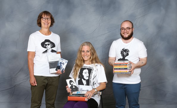 Tre skolbibliotekarier klädda i varsin tröja med tryck, gjorda av elever i SKD19. Från vänster: Elisabet, Karin och Sebastian.